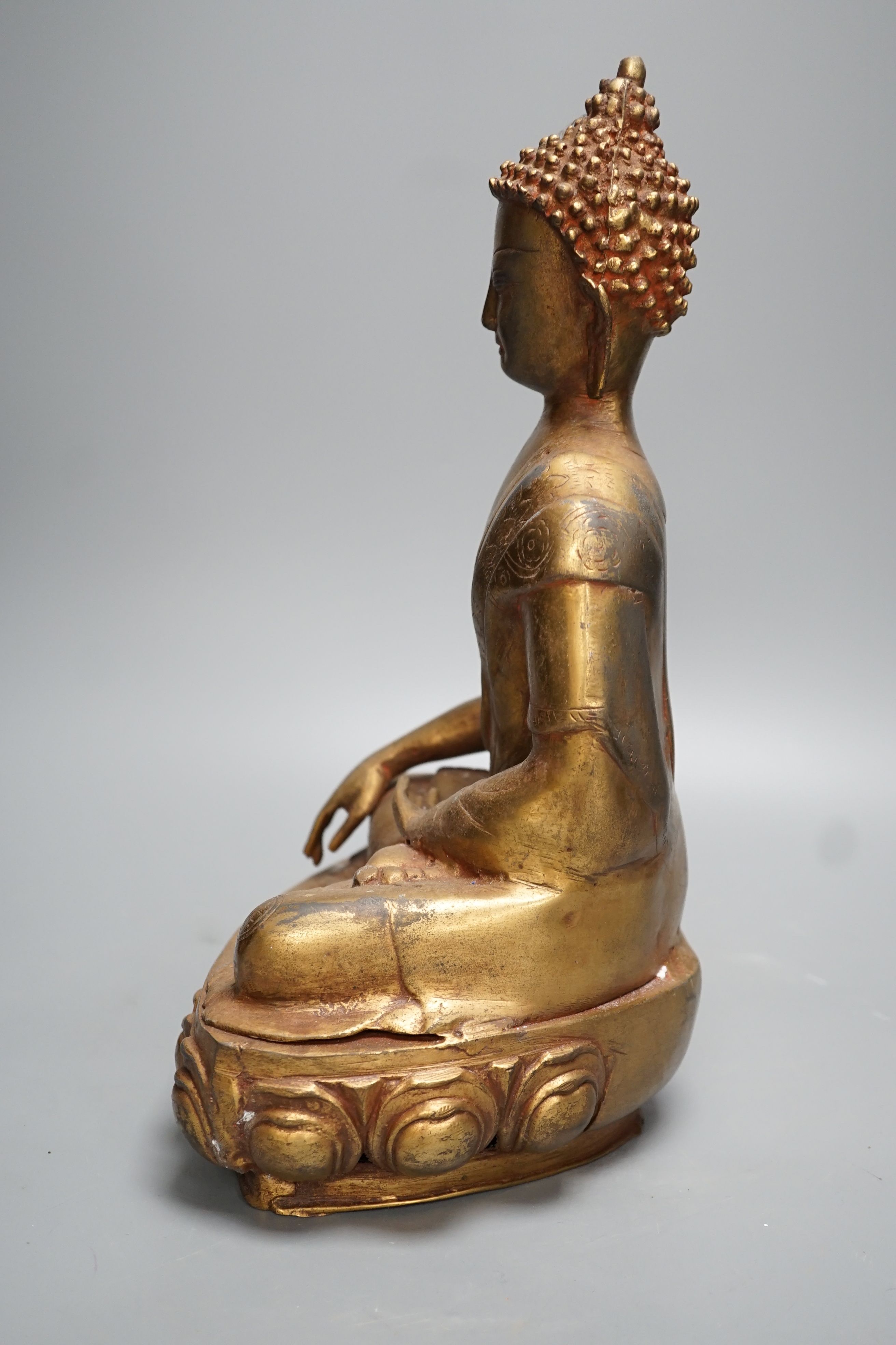 A gilt brass seated figure of Buddha - 38cm high